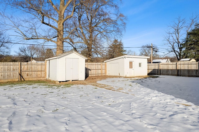 snowy yard featuring a shed