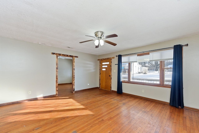 unfurnished room featuring ceiling fan, wood-type flooring, and a textured ceiling