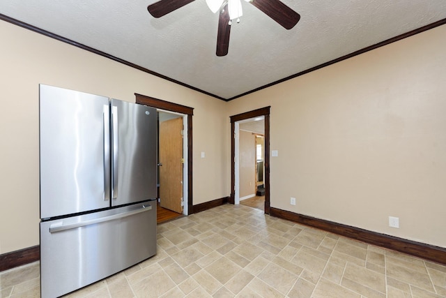 kitchen with crown molding, a textured ceiling, and stainless steel refrigerator