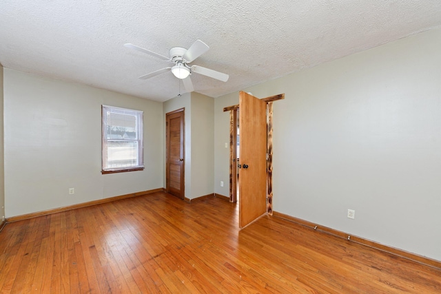 empty room featuring light wood-type flooring, ceiling fan, and a textured ceiling