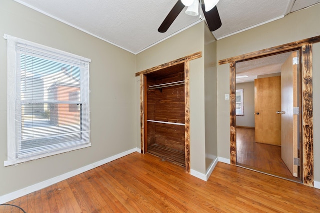 unfurnished bedroom featuring ceiling fan, a textured ceiling, a closet, and light hardwood / wood-style flooring