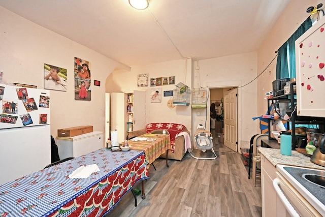 bedroom with hardwood / wood-style flooring and white fridge