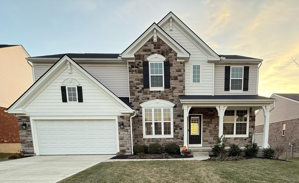 view of front of property with a garage and a lawn