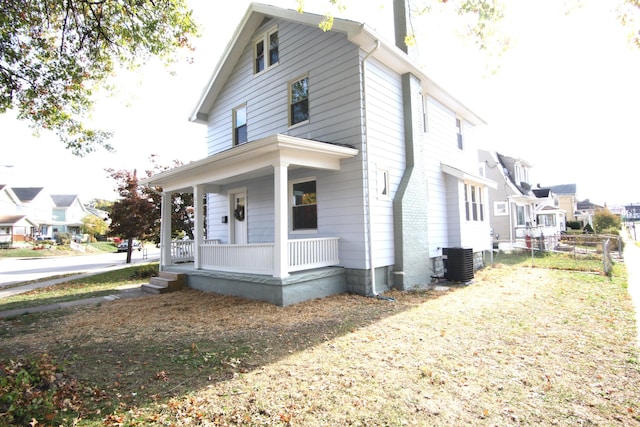 view of side of property featuring central AC unit and covered porch