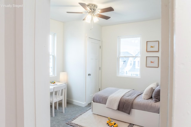 carpeted bedroom with multiple windows and ceiling fan