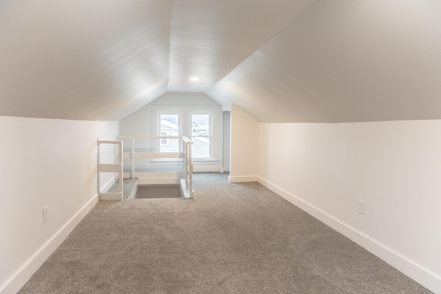 additional living space featuring lofted ceiling and carpet floors