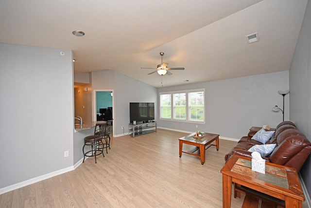 living room with lofted ceiling, light hardwood / wood-style flooring, and ceiling fan