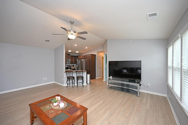 living room with ceiling fan, lofted ceiling, and light hardwood / wood-style floors