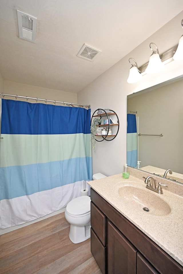 bathroom with hardwood / wood-style flooring, vanity, toilet, and a shower with curtain