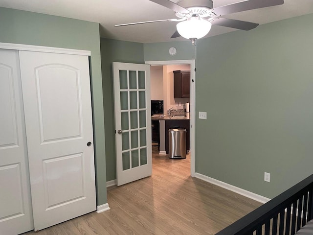 bedroom with ceiling fan, a closet, and light wood-type flooring