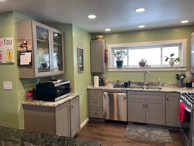 kitchen with light stone counters, sink, gray cabinets, and stainless steel appliances