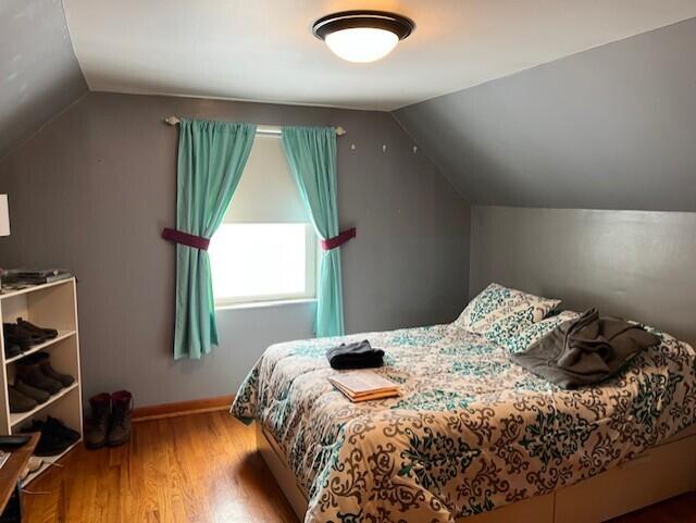 bedroom featuring hardwood / wood-style flooring and vaulted ceiling