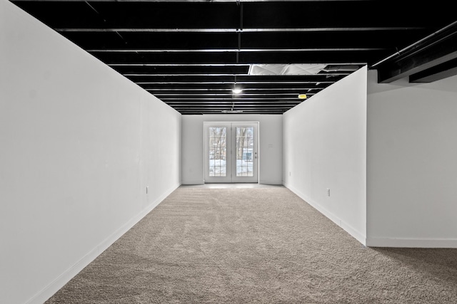 basement featuring french doors and carpet