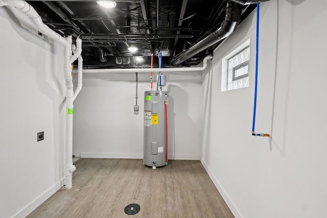 basement with electric water heater and light wood-type flooring