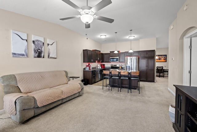 carpeted living room with ceiling fan and vaulted ceiling