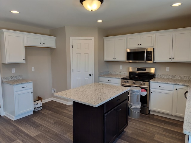 kitchen featuring white cabinetry, dark hardwood / wood-style flooring, a center island, stainless steel appliances, and light stone countertops