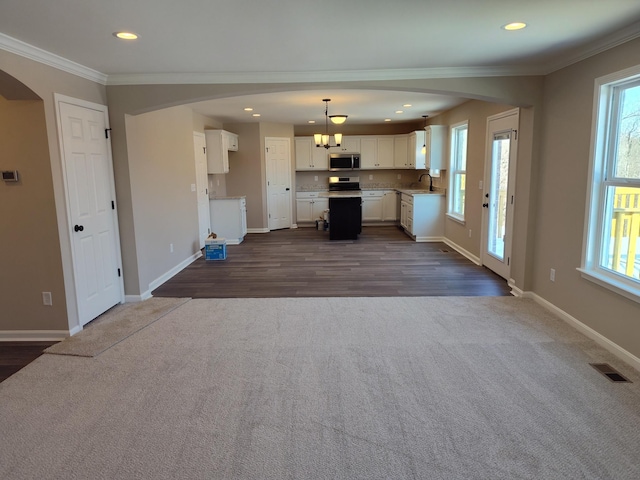 interior space featuring ornamental molding, dark hardwood / wood-style flooring, sink, and a healthy amount of sunlight