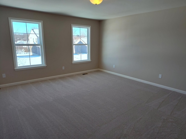 carpeted spare room featuring a healthy amount of sunlight