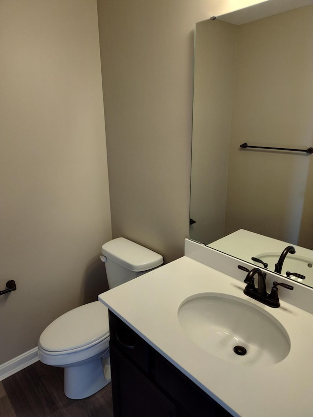 bathroom featuring vanity, hardwood / wood-style floors, and toilet