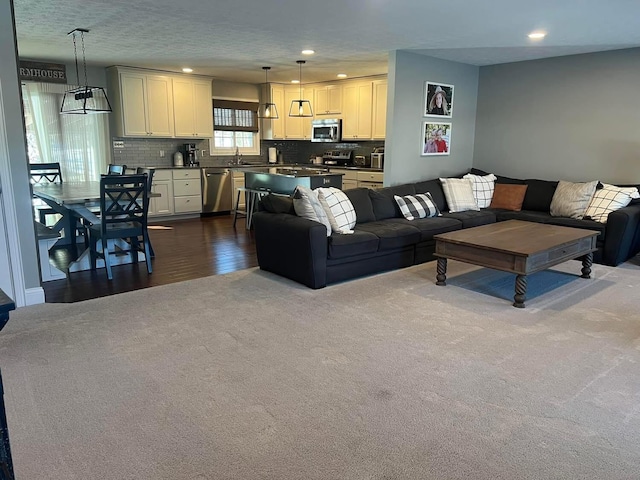 carpeted living room featuring sink