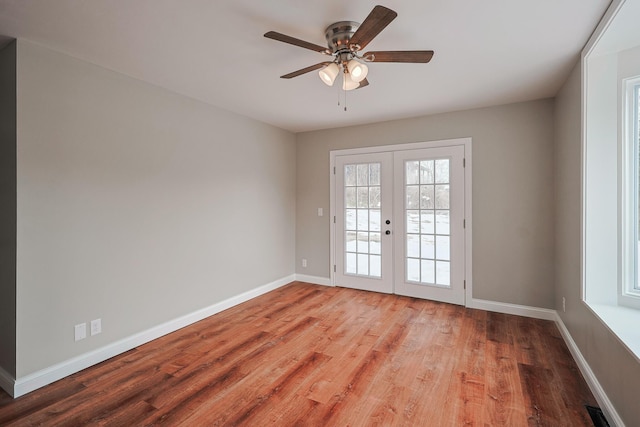 unfurnished room featuring hardwood / wood-style floors, ceiling fan, and french doors