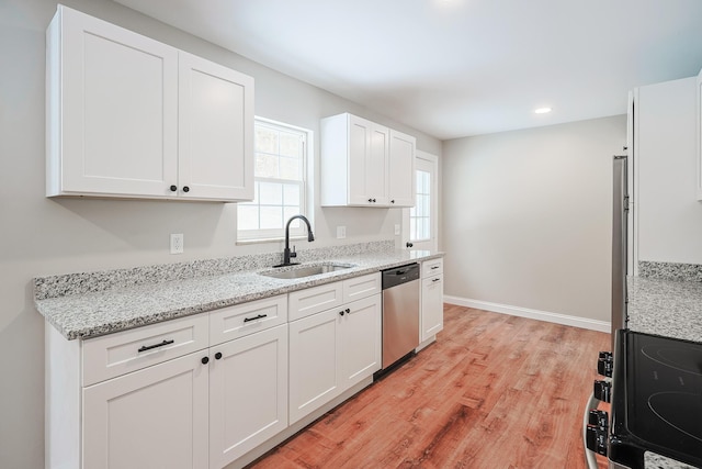 kitchen with sink, dishwasher, white cabinetry, light stone countertops, and light wood-type flooring