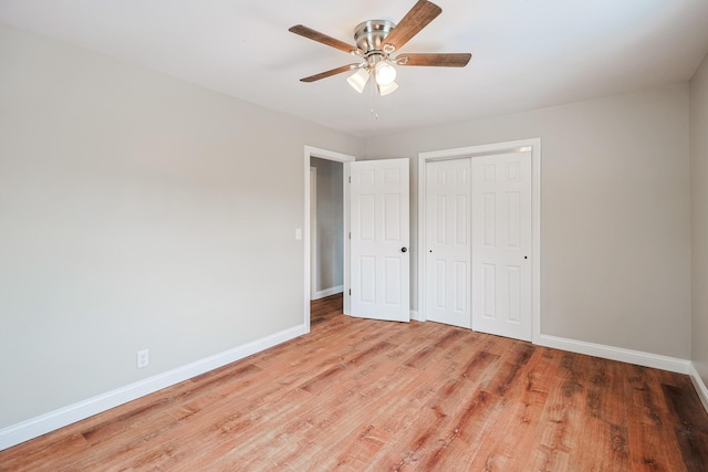 unfurnished bedroom featuring ceiling fan, a closet, and light wood-type flooring