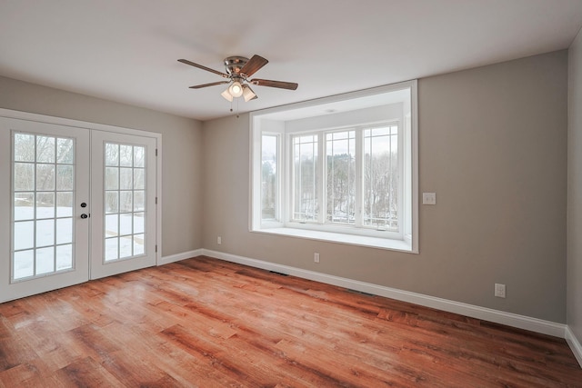 empty room featuring french doors, ceiling fan, and light hardwood / wood-style floors