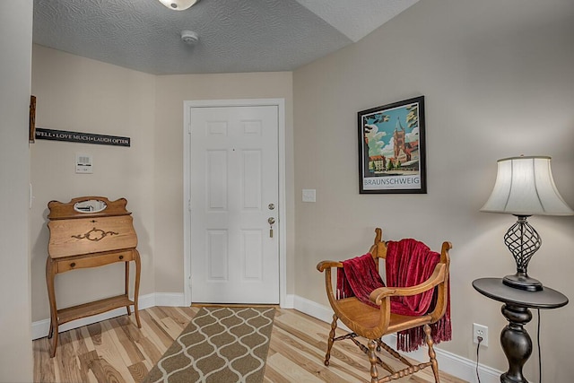 entryway with light hardwood / wood-style floors and a textured ceiling