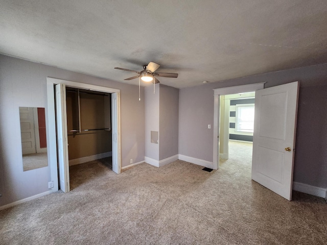 unfurnished bedroom featuring light colored carpet, a textured ceiling, ceiling fan, and a closet