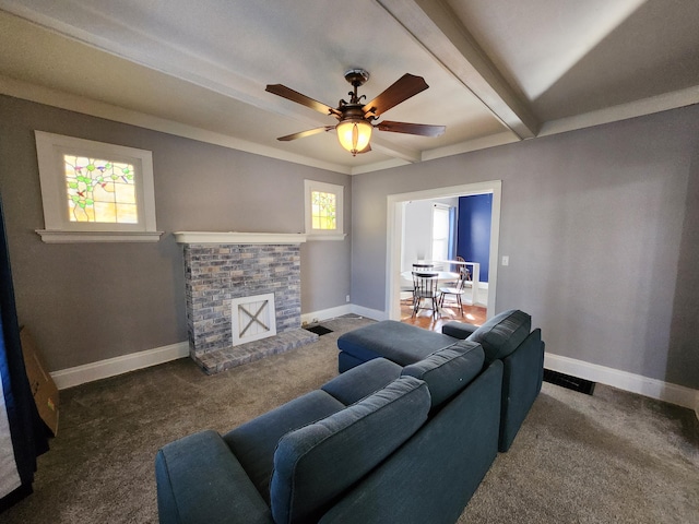 carpeted living room with beamed ceiling, ornamental molding, a brick fireplace, and ceiling fan