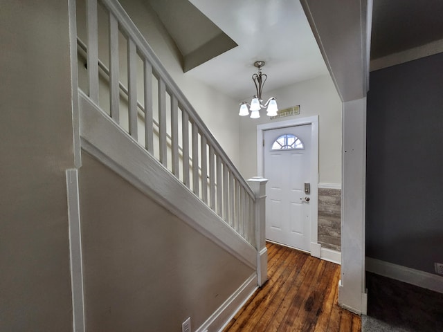 entryway featuring dark hardwood / wood-style flooring and an inviting chandelier