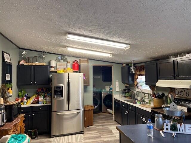 kitchen featuring lofted ceiling, sink, black appliances, washer and dryer, and a textured ceiling