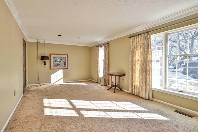 empty room featuring ornamental molding, a wealth of natural light, and light colored carpet