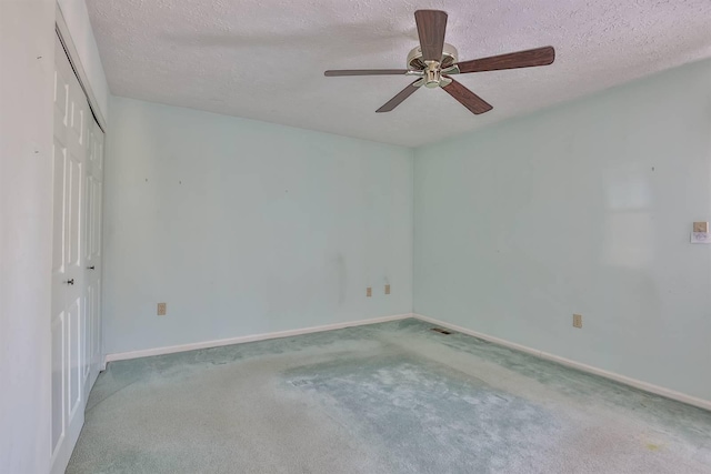 carpeted empty room with ceiling fan and a textured ceiling