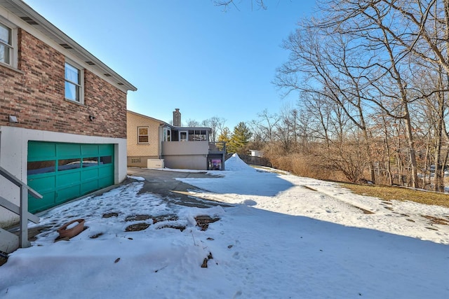 yard covered in snow featuring a garage