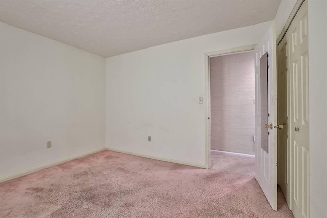 unfurnished room featuring light colored carpet and a textured ceiling