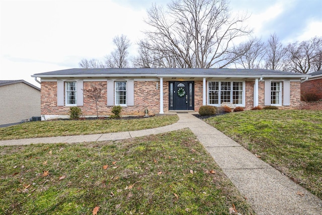 single story home with brick siding and a front yard