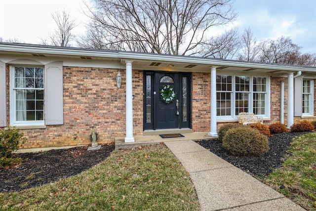 entrance to property featuring brick siding