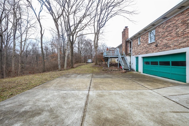 view of yard with stairs, concrete driveway, and an attached garage