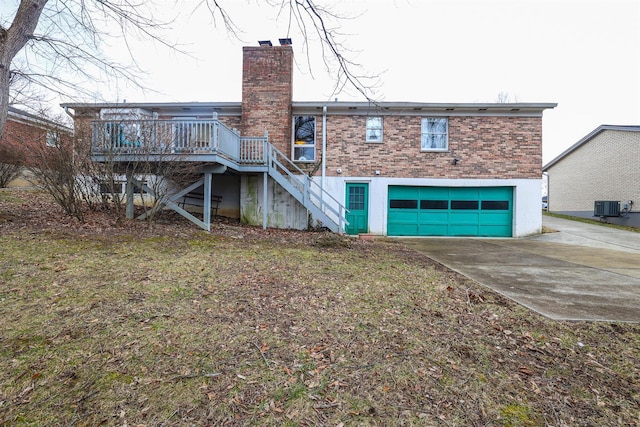 rear view of house featuring central AC, brick siding, driveway, stairway, and a chimney