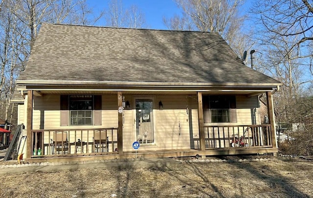 view of front facade featuring a shingled roof and covered porch