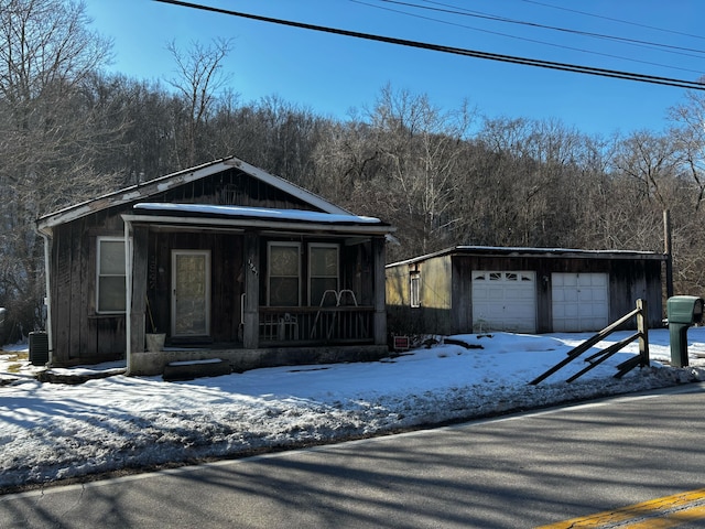 view of front of property with a garage, an outdoor structure, and a porch