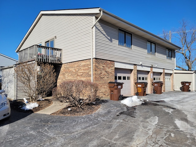 view of side of property featuring a garage and a balcony