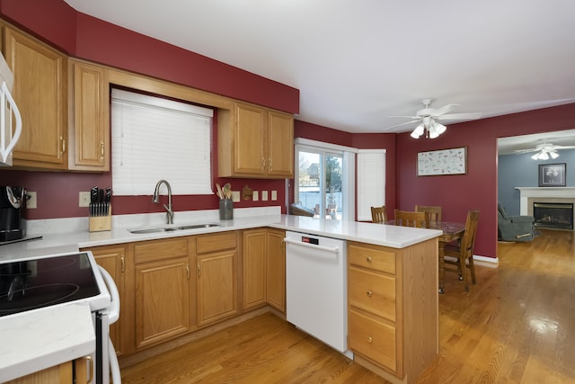 kitchen with light hardwood / wood-style floors, sink, white appliances, and kitchen peninsula