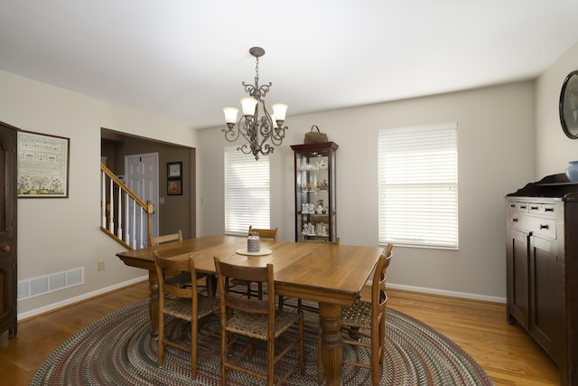 dining room featuring plenty of natural light, light hardwood / wood-style floors, and a notable chandelier