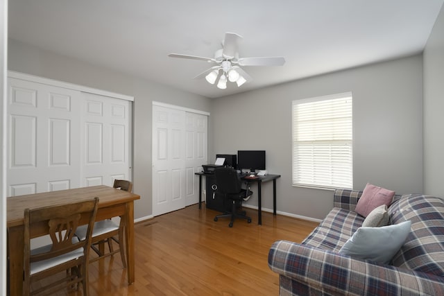 home office with ceiling fan and light hardwood / wood-style flooring