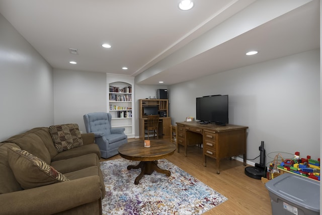 living room with built in features and light wood-type flooring