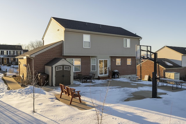 snow covered property featuring a storage shed