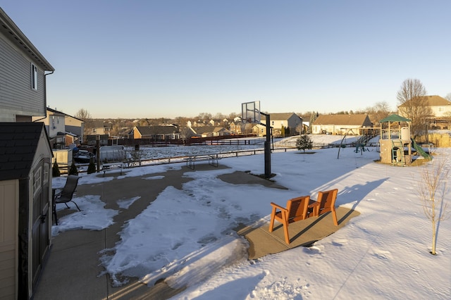 snowy yard featuring a playground